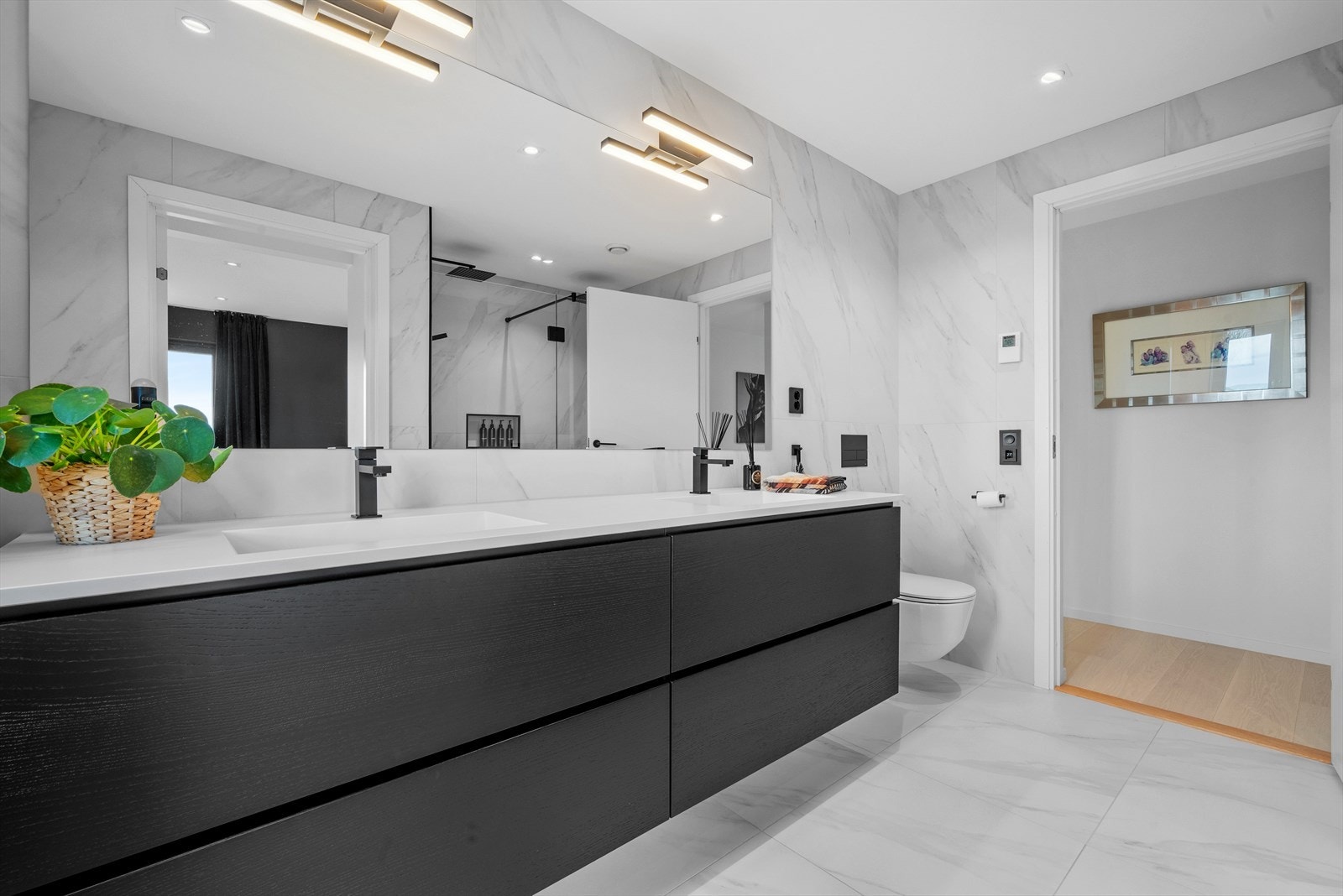 Et bad der ingen detaljer er oversett: dobbel dusj, dobbel servant og gjennomtenkt oppbevaring skaper en perfekt balanse mellom luksus og praktisk bruk. Galleribilde