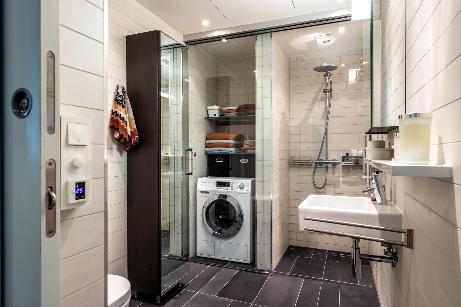 Leiligheten har et delikat bad beliggende ved entréen. Videre har badet dusjnisje med glassdør, servant, speilskap, høyskap med speil og vegghengt toalett. Det er elektriske varmekabler i gulv og downlightsbelysning i himlingen Galleribilde
