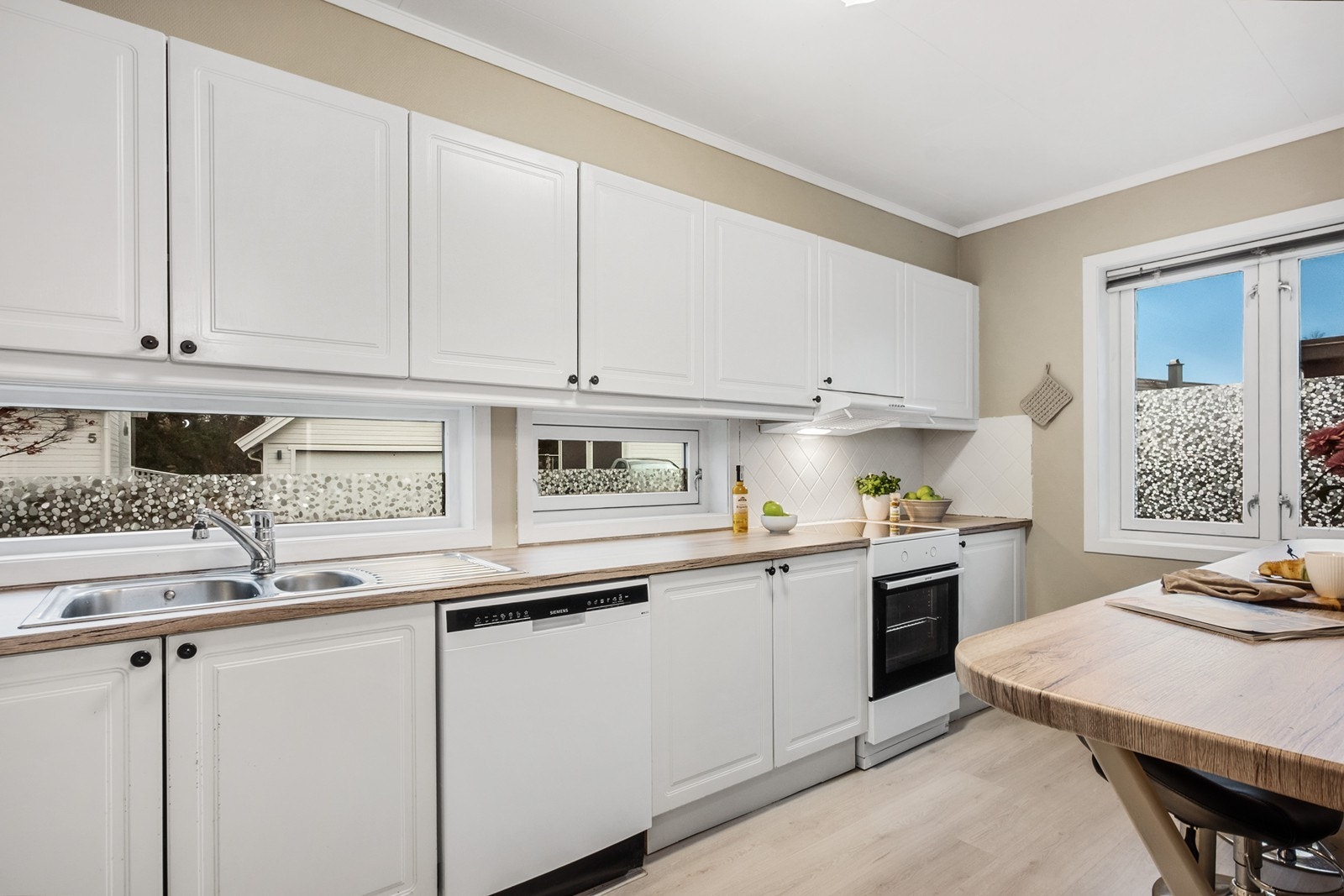 Kjøkkenet er effektivt innredet med god skap- og benkeplass, samt frittstående komfyr, kjøleskap og underbygget oppvaskmaskin. Galleribilde