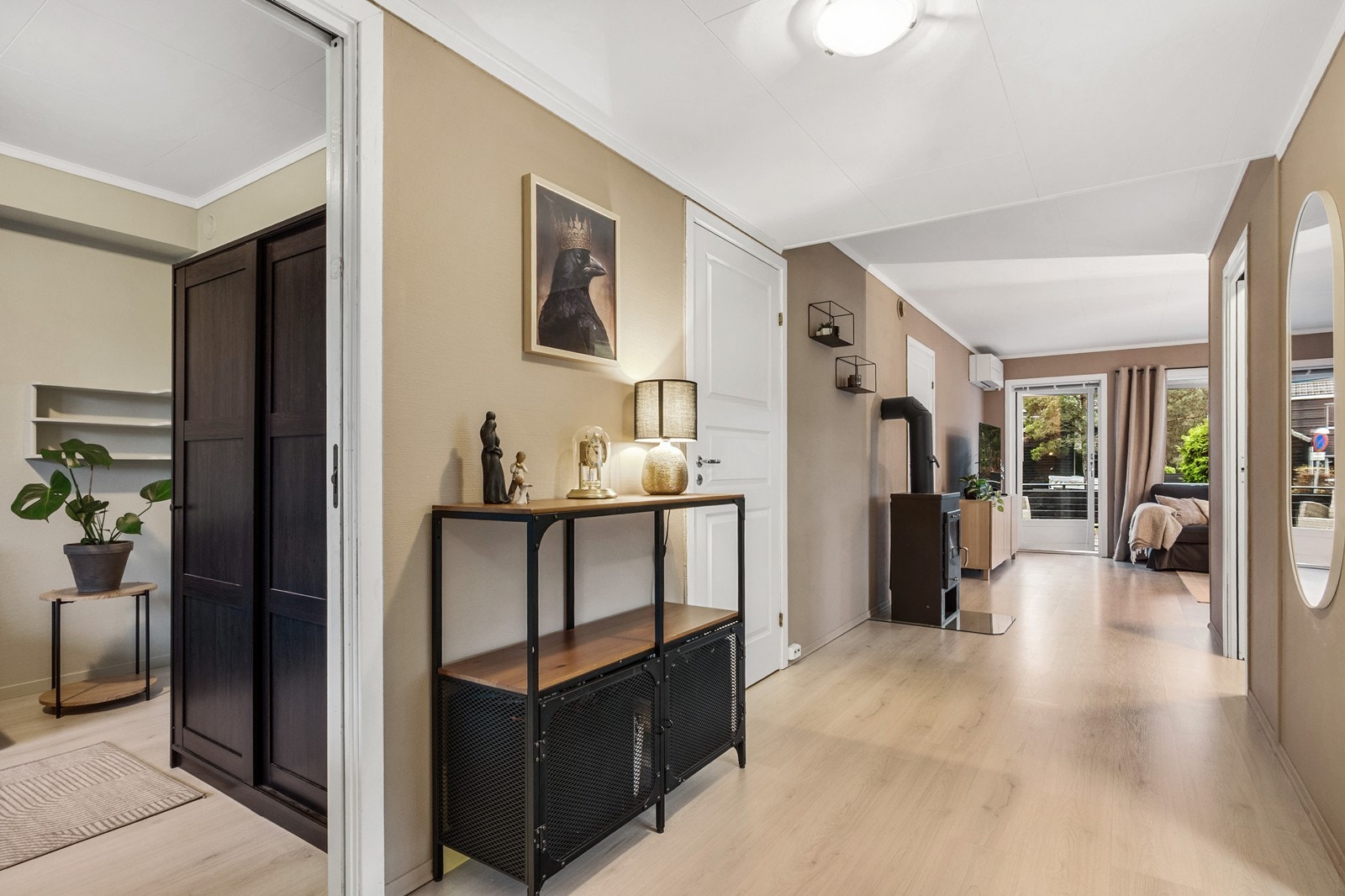 Lyse gulv og varme fargetoner gir en behagelig flyt fra gangen og videre inn i boligen. Galleribilde