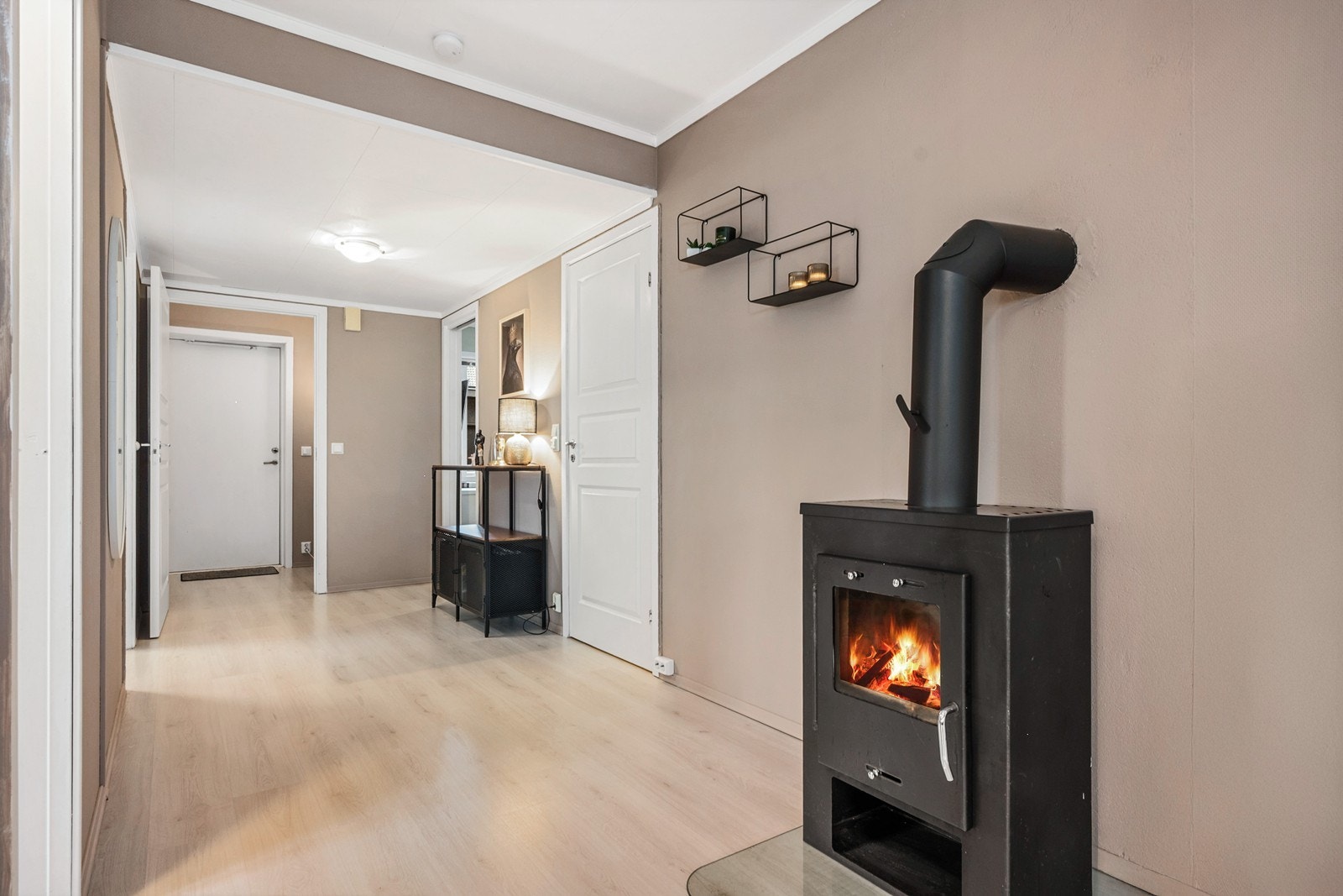 En hyggelig peisovn står sentralt i rommet og gir både varme og stemning, supplert av varmepumpe fra 2024. Galleribilde