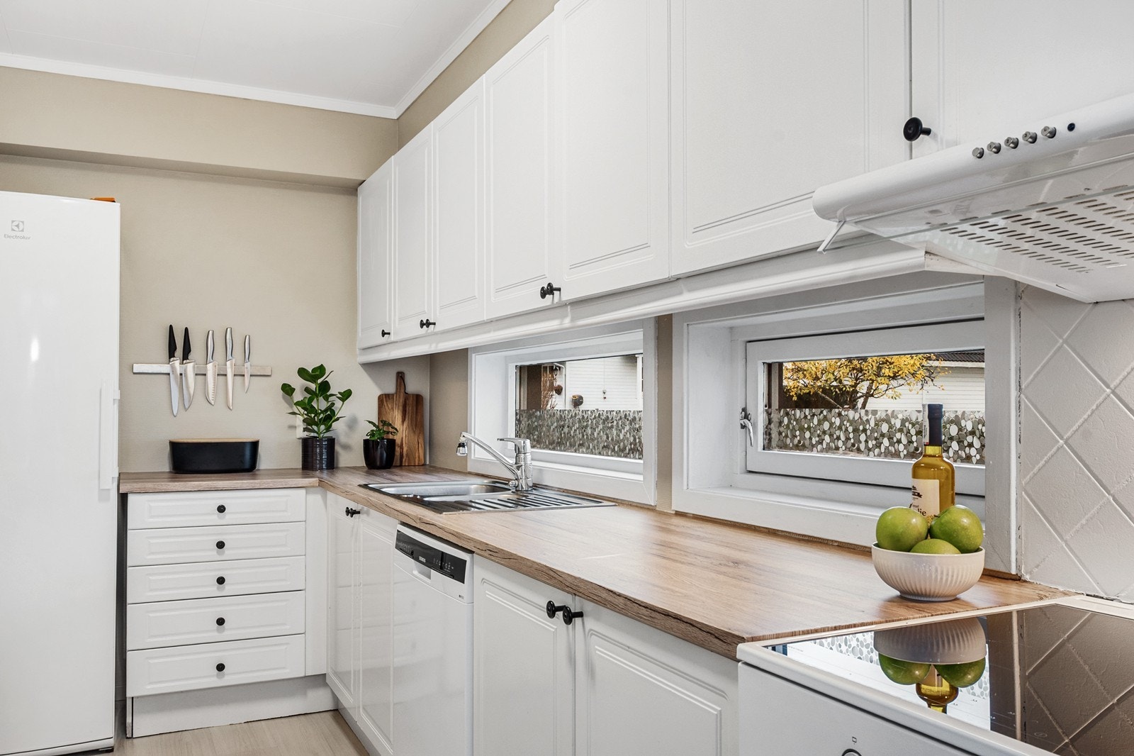 Kjøkkenet ligger i eget rom med god størrelse. Innredningen er tidløs med hvite, profilerte fronter og benkeplate i laminat. Galleribilde