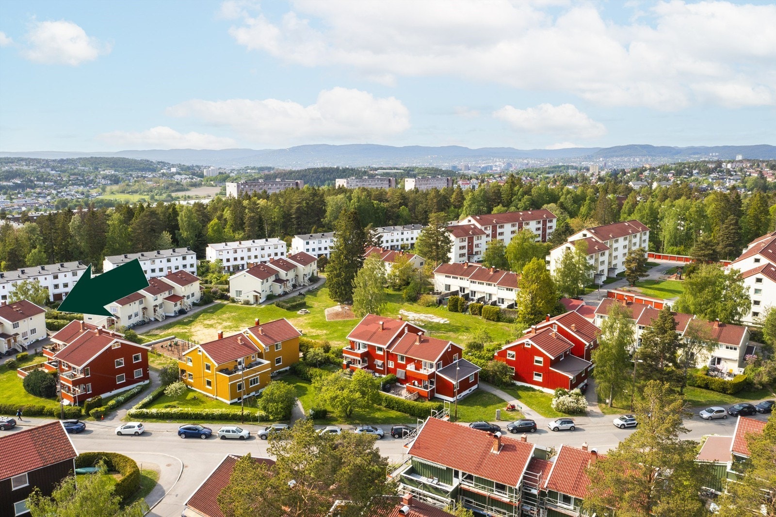 Drone sommerstid -Boligen ligger flott til internt i borettslaget. Mye grønt og fellesarealer omkranser firemannsboligene og rekkehusene. Galleribilde