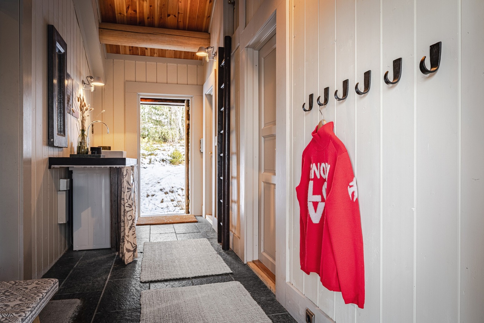 Entré med utgang på begge sider. I enden av rommet er det opplegg for vaskemaskin. Over det ene soverommet er det adkomst til en hems med et gulvareal på 11 m². Galleribilde