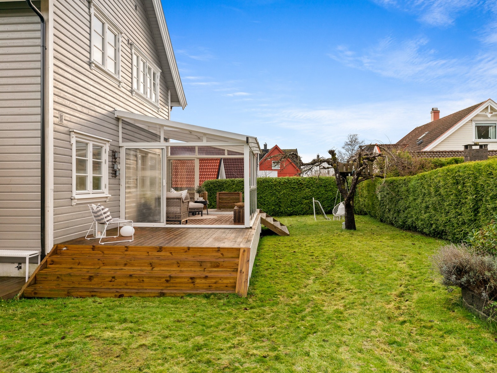 Den grønne, lettstelte tomten omkranser huset og gir rikelig plass til lek, trampoliner, fotballmål og hageselskap. Galleribilde