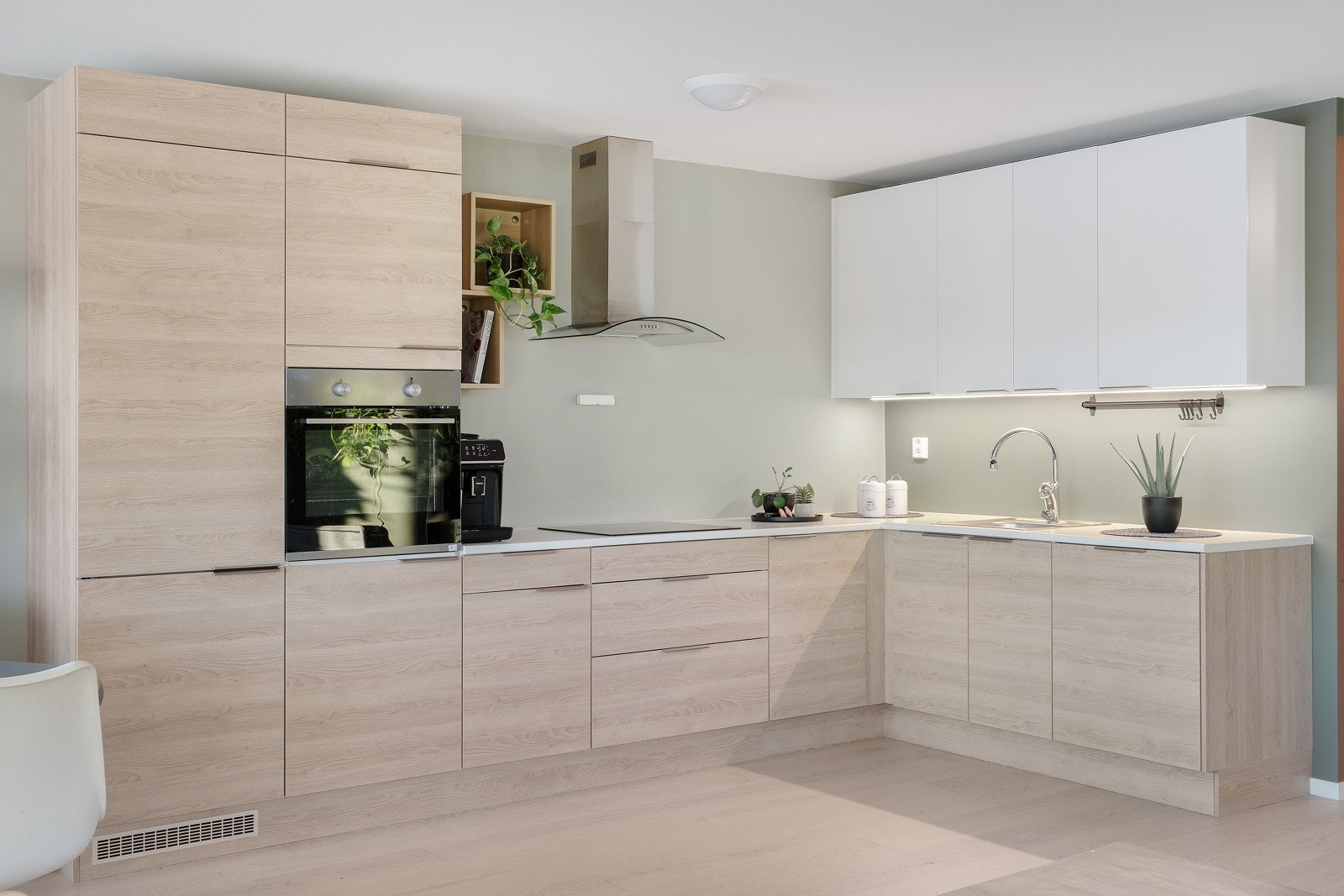 Innredning med glatte fronter, helintegrert kjøl-/fryseskap, stekeovn i arbeidshøyde, oppvaskmaskin og indusksjon steketopp. Galleribilde