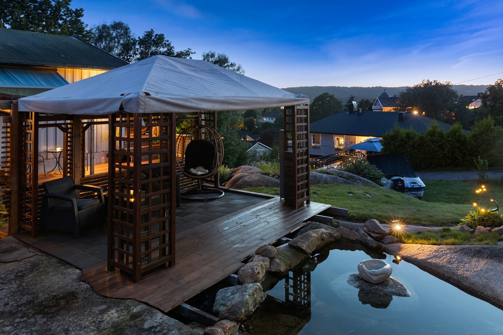 Bak huset finner du en sjarmerende hage med pergola og blomstrende detaljer Galleribilde
