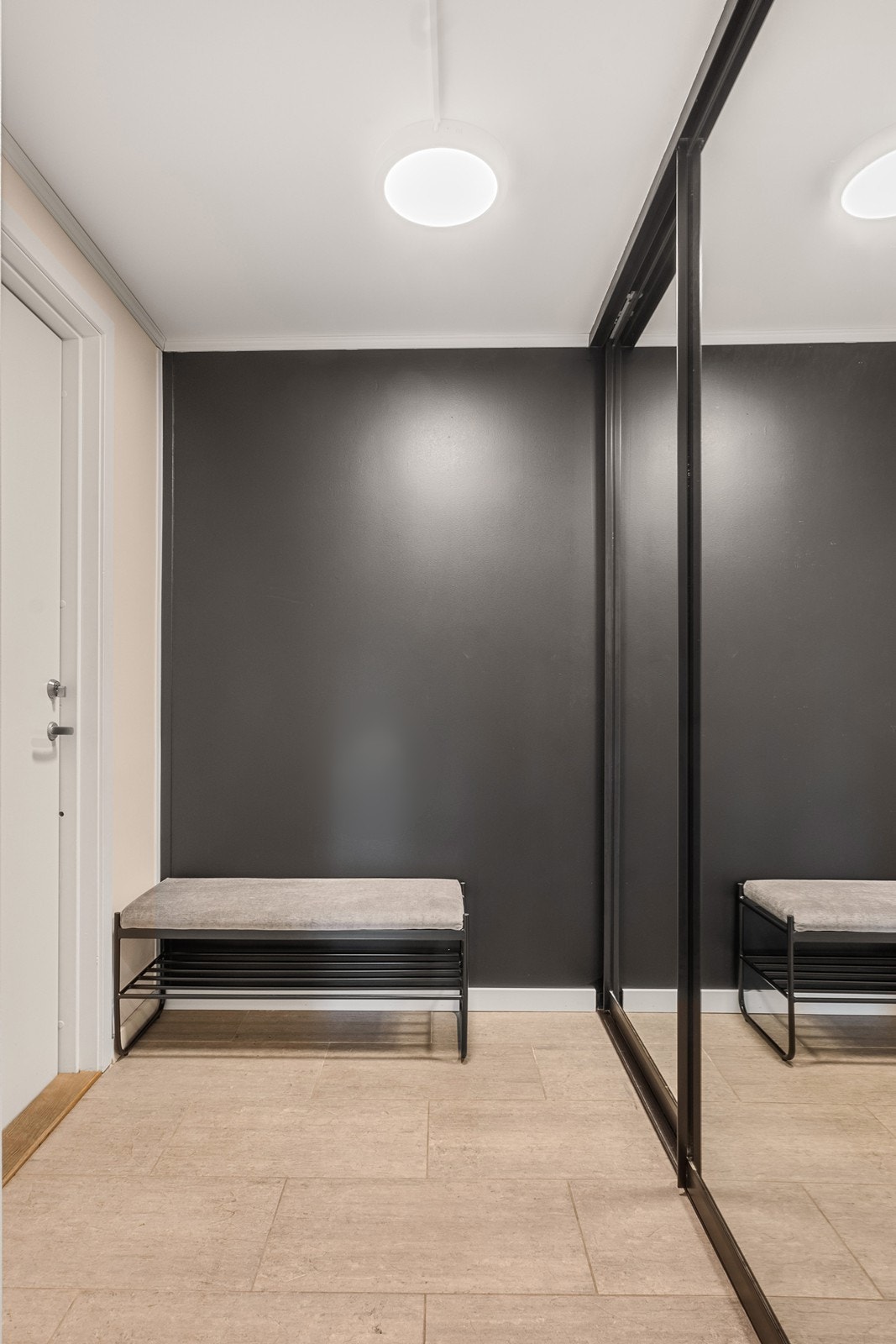 Vel inne er en flislagt entré med gulvvarme og stor skyvedørsgarderobe for rikelig med plass til klær, tilbehør og sko. Galleribilde