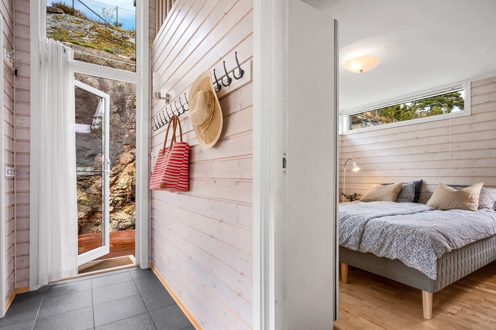 Entreen er plassert på vestsiden av hytta, med flislagt gulv med varme og knaggrekker for oppheng. Galleribilde