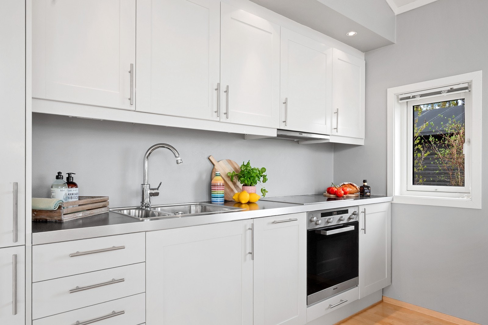 Kjøkkenet har innredning på én vegg med over- og underskap og integrerte hvitevarer. Galleribilde