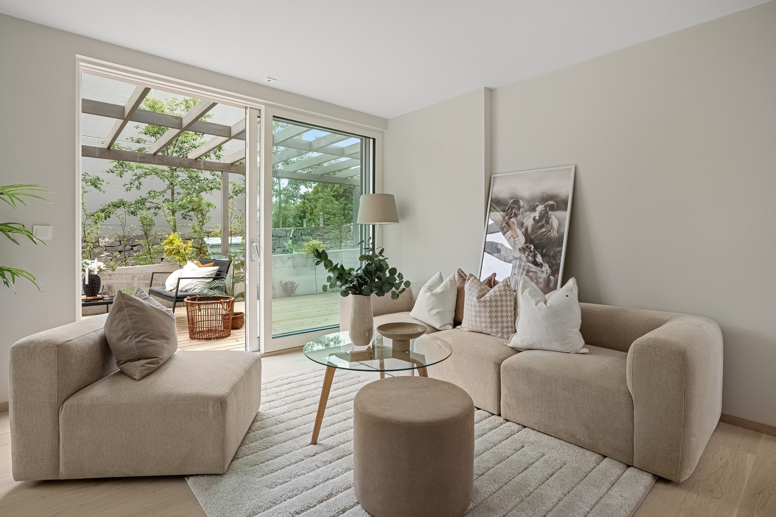 En herlig stue i 1. etasje med store vindusflater ut om den private, romslige terrassen med pergola Galleribilde