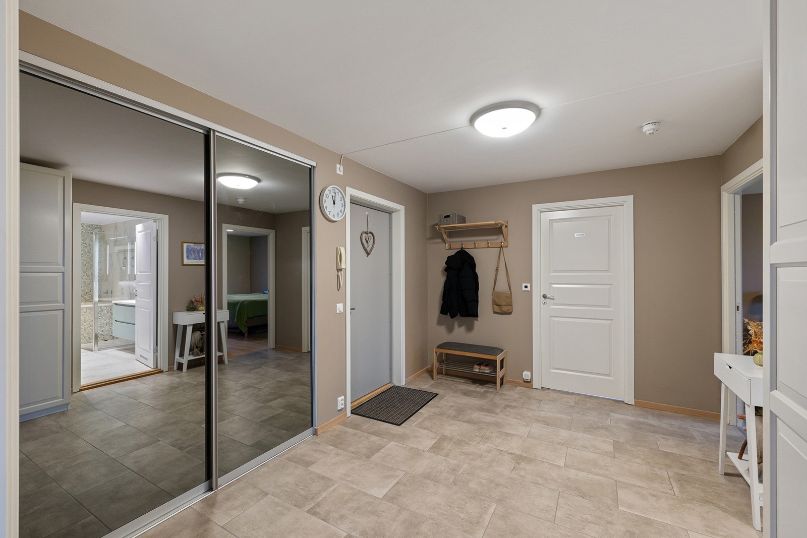 Stor og innbydende entré med fliser og gulvvarme som gir ekstra komfort. Skyvedørsgarderoben med speil gir både god lagringsplass og en romslig følelse. Galleribilde