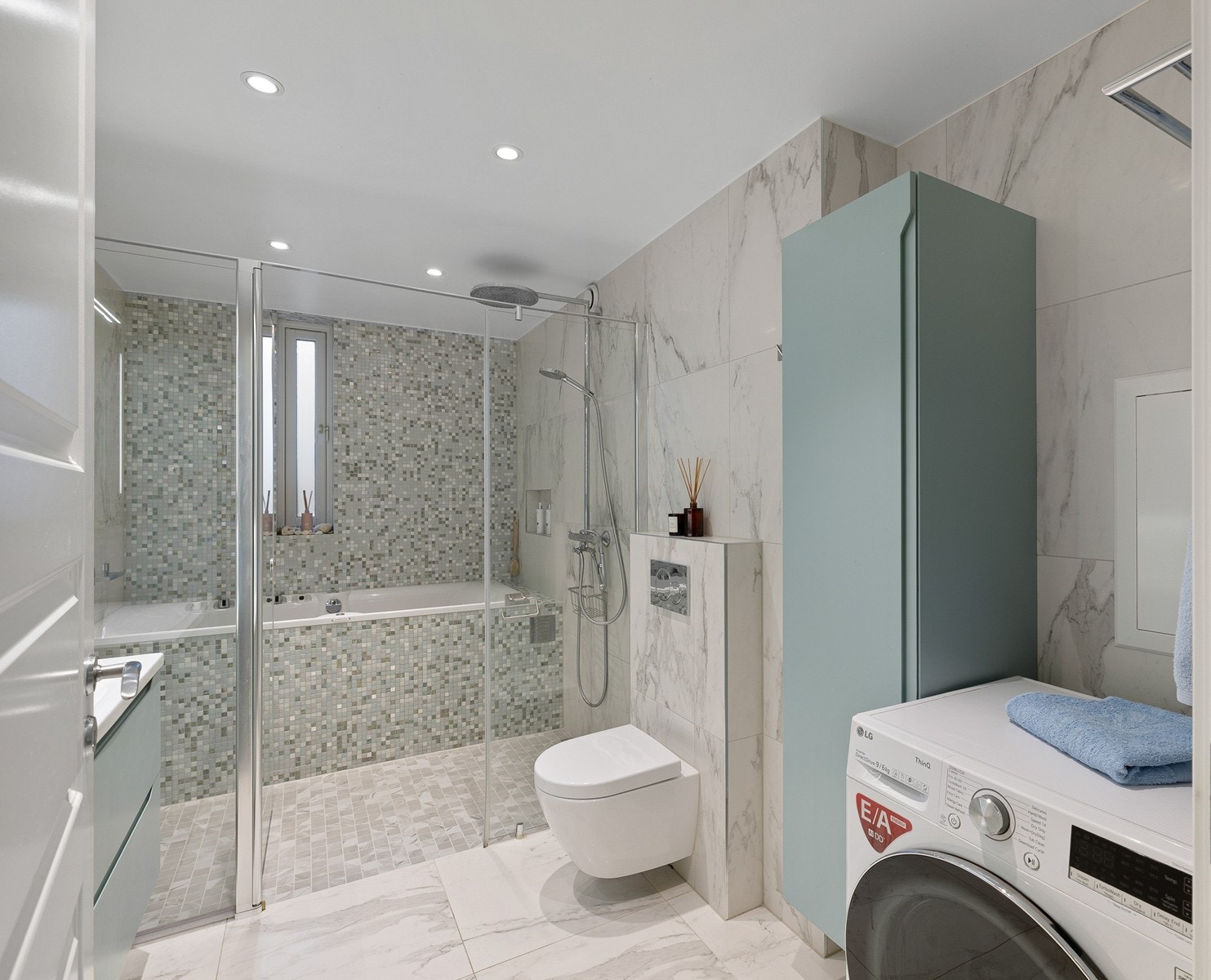 Badet er innredet med dusjnisje, stort innbygd badekar, vegghengt toalett og praktisk baderomsinnredning med god oppbevaring. Galleribilde