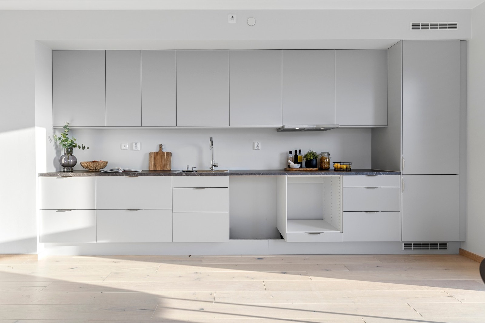 Delikat og tidsriktig kjøkken fra Norema i åpen løsning mot stuen. Det er montert integrerte hvitevarer som medfølger salget. Galleribilde