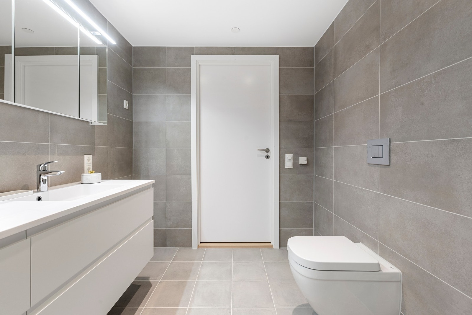 Delikat og romslig flislagt hovedbad med vannbåren varme i gulv Galleribilde