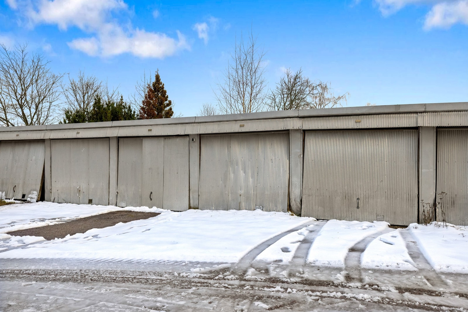 Med leiligheten følger en garasje i felles garasjerekke. Garasjene er av eldre dato. Galleribilde