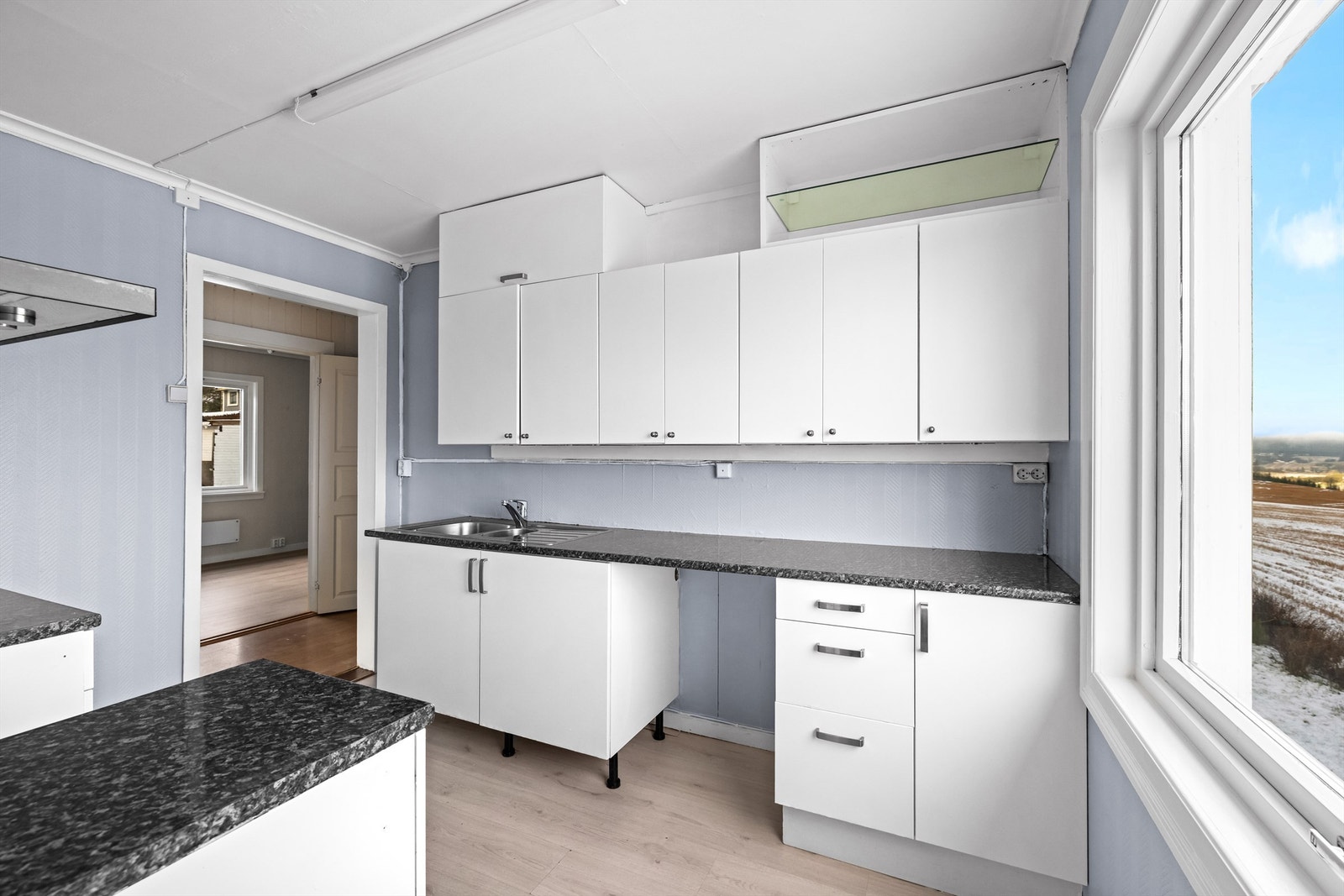 Rommet har laminatgulv, malte strietapetvegger og et stort vindu som gir flott utsikt mot naturen. Galleribilde