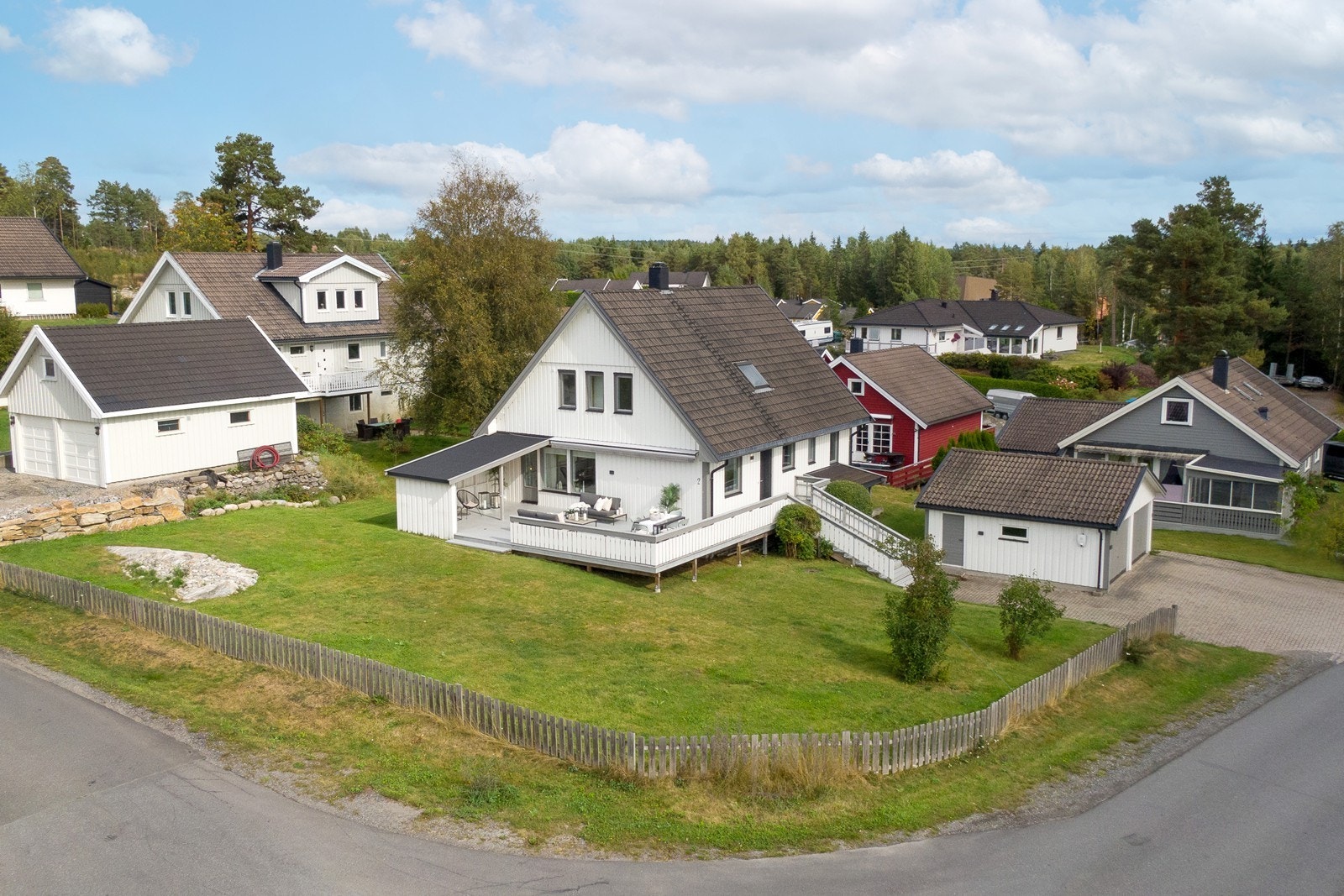 Eiendommen ligger på en solrik og pent opparbeidet hjørnetomt på 984 kvm, med stor hage og steinbelagt gårdsplass. Galleribilde