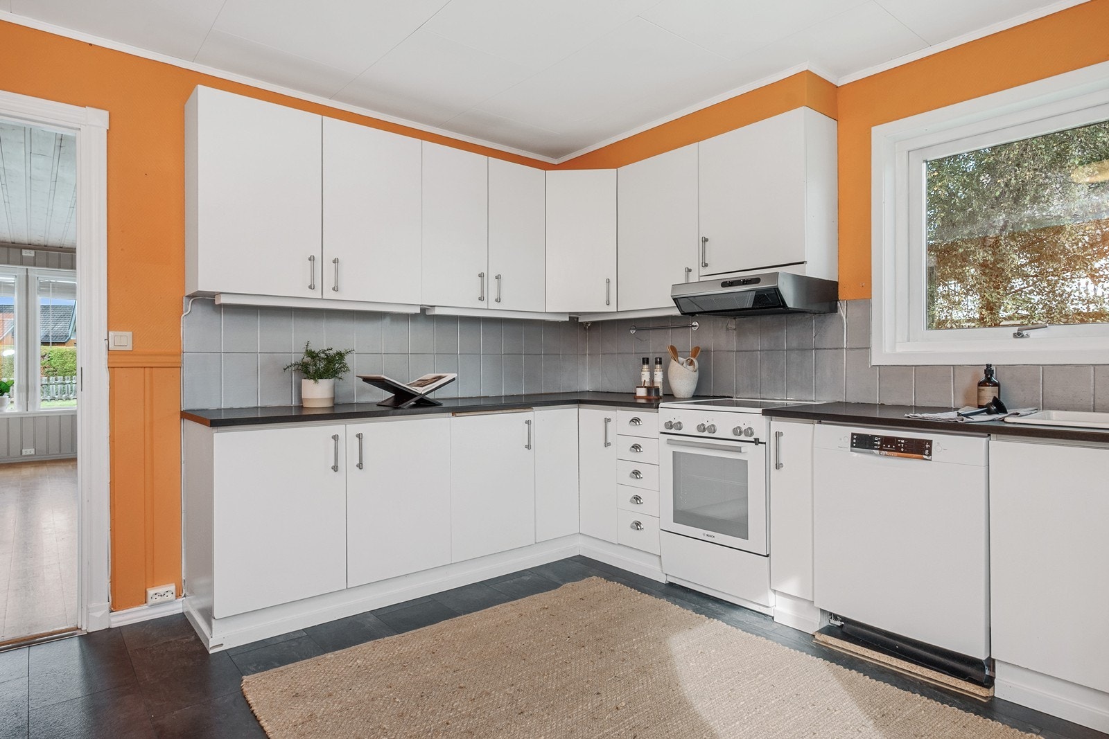 Kjøkkenet ligger adskilt fra stuen og har slette fronter, laminat benkeplate og fliser over benk. Galleribilde