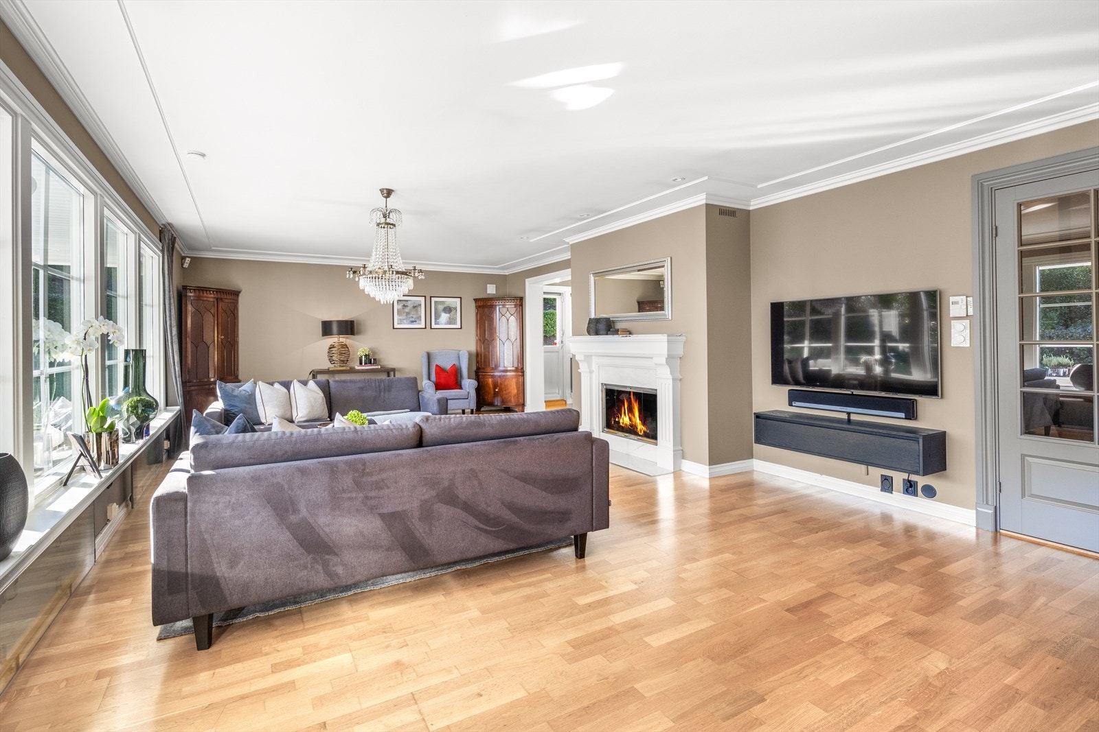 Fra stuen er det direkte utgang til en romslig hage og en delvis takoverbygget uteplass Galleribilde