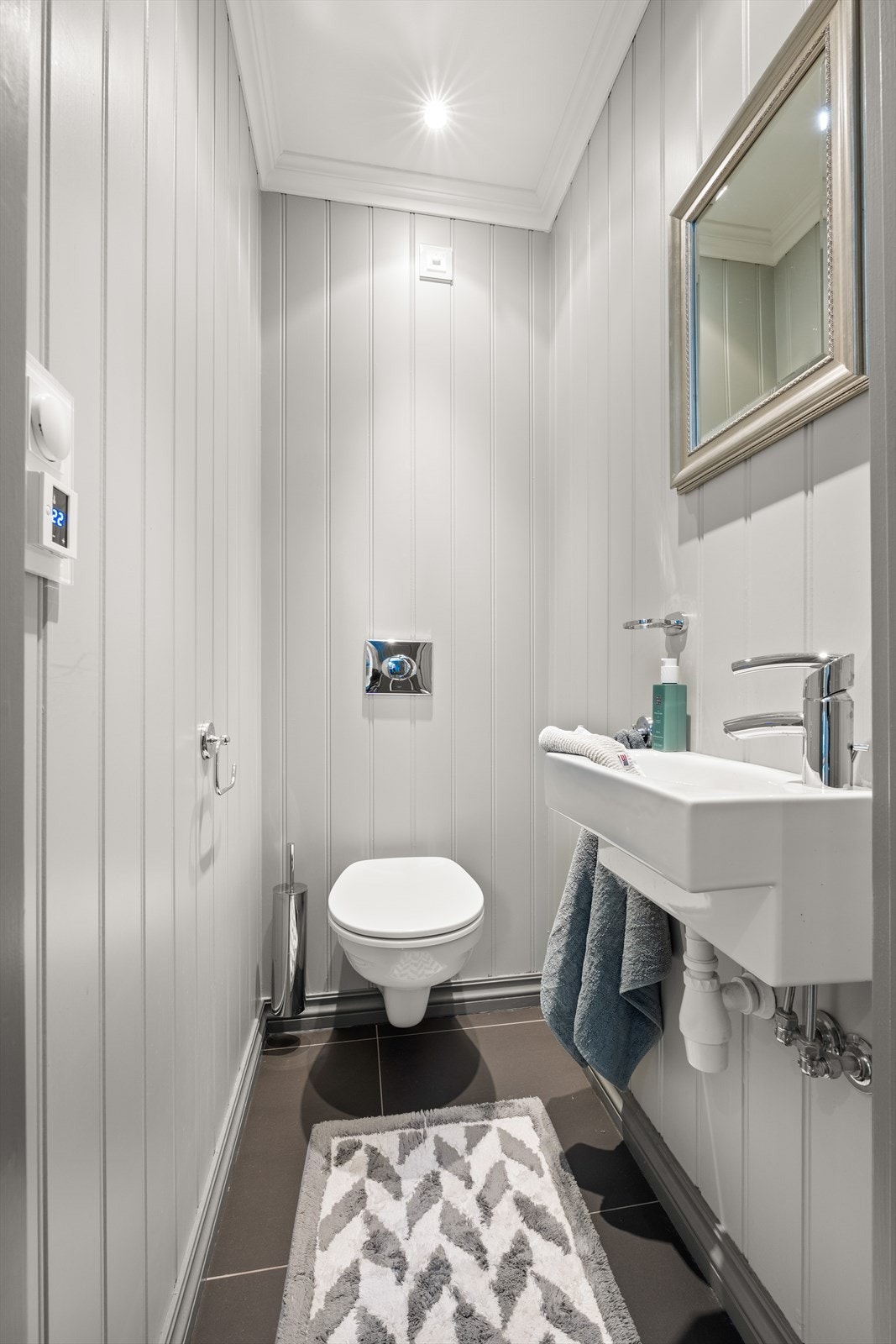 Toalettrom i tilknytning til entré. Det er fliser på gulv og behagelig varme i gulvet Galleribilde