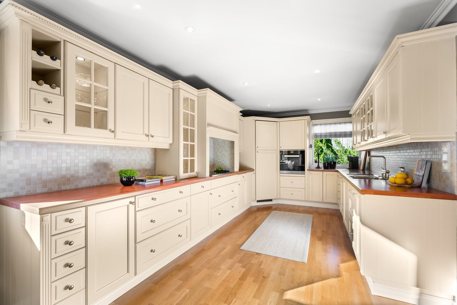 Innredningen har profilerte fronter og fliser over benk, og det er integrerte hvitevarer - blant annet et praktisk kjølehjørne Galleribilde