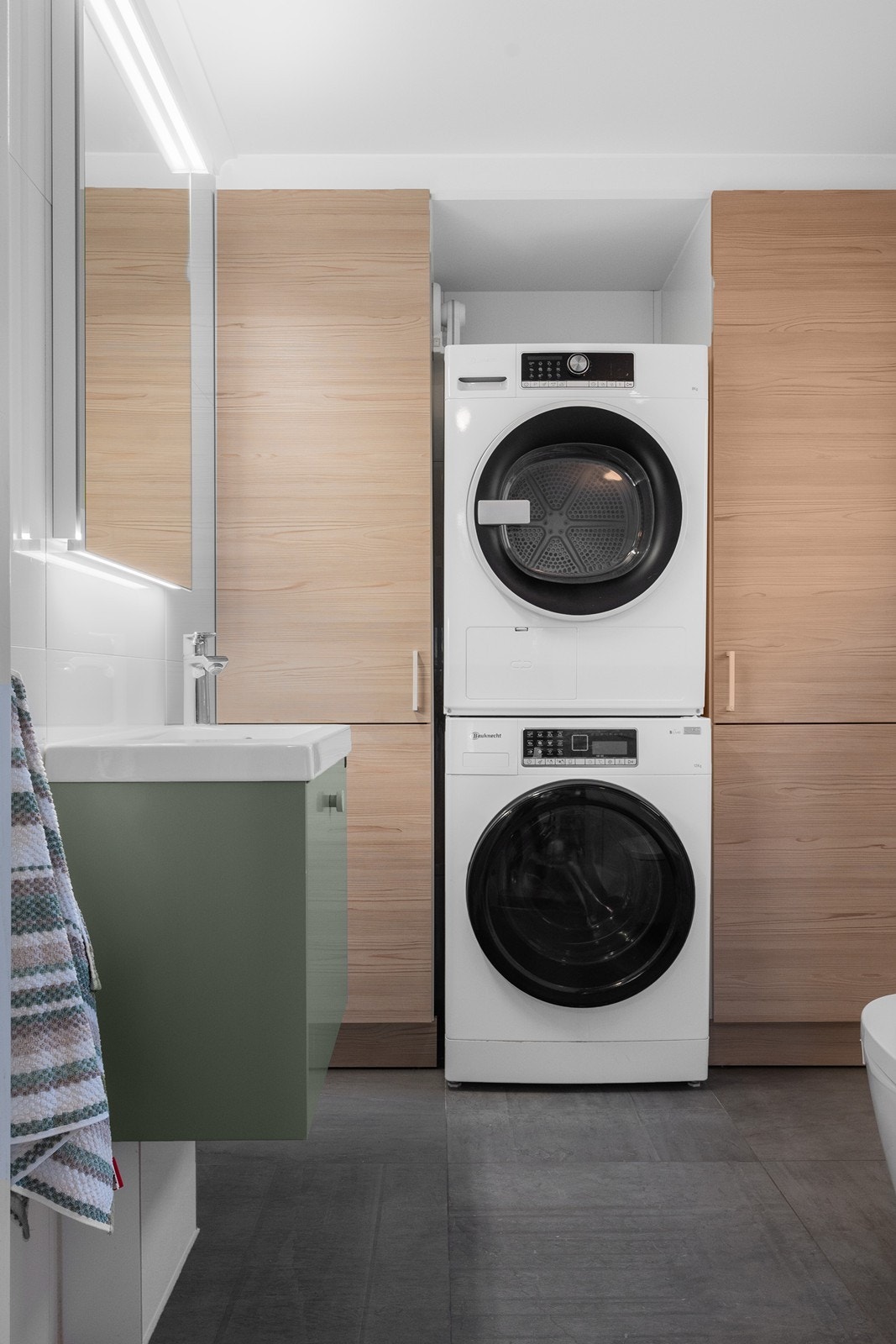 I tilknytning til hallen ligger toalettrommet kombinert med vaskerom. Rommet har flislagte overflater og gulvvarme, samt vegghengt toalett og servant. Plass til både vaskemaskin, tørketrommel og høyskap gir gode oppbevaringsmuligheter. Galleribilde