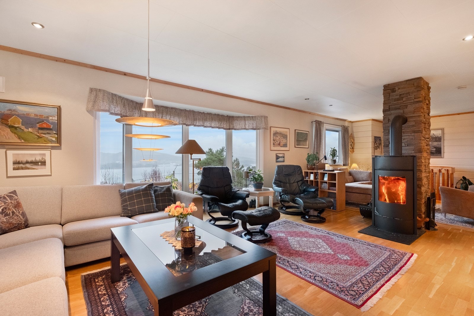 Romslig stue med ildsted og karnapp med utsikt Galleribilde