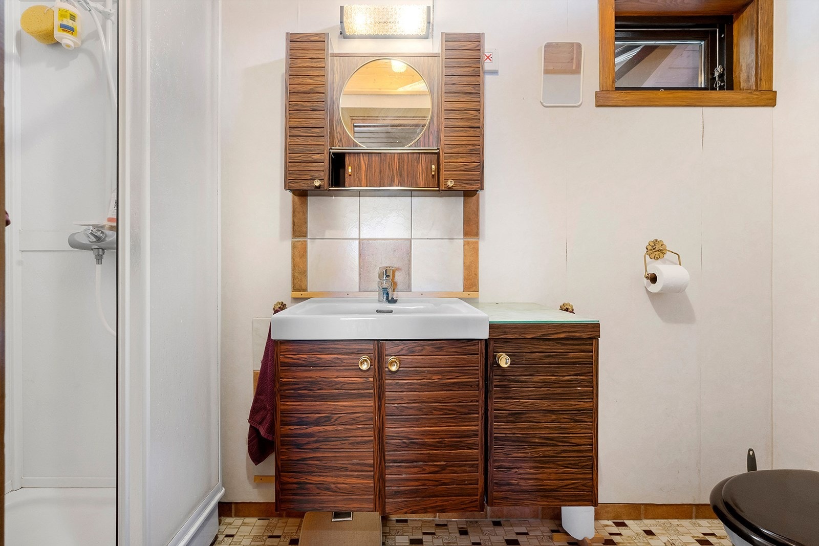 Badet i hovedetasjen har flistlagt gulv med varmekabler og er innredet med toalett, dusj, servant og speil. Galleribilde