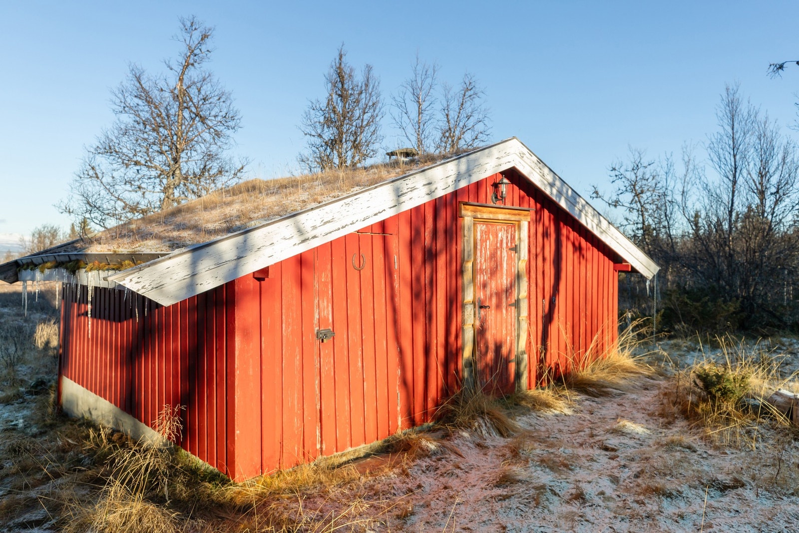 Uthuset har rom med dusjkabinett og vedovn, rom for oppbevaring samt rom med utedo Galleribilde