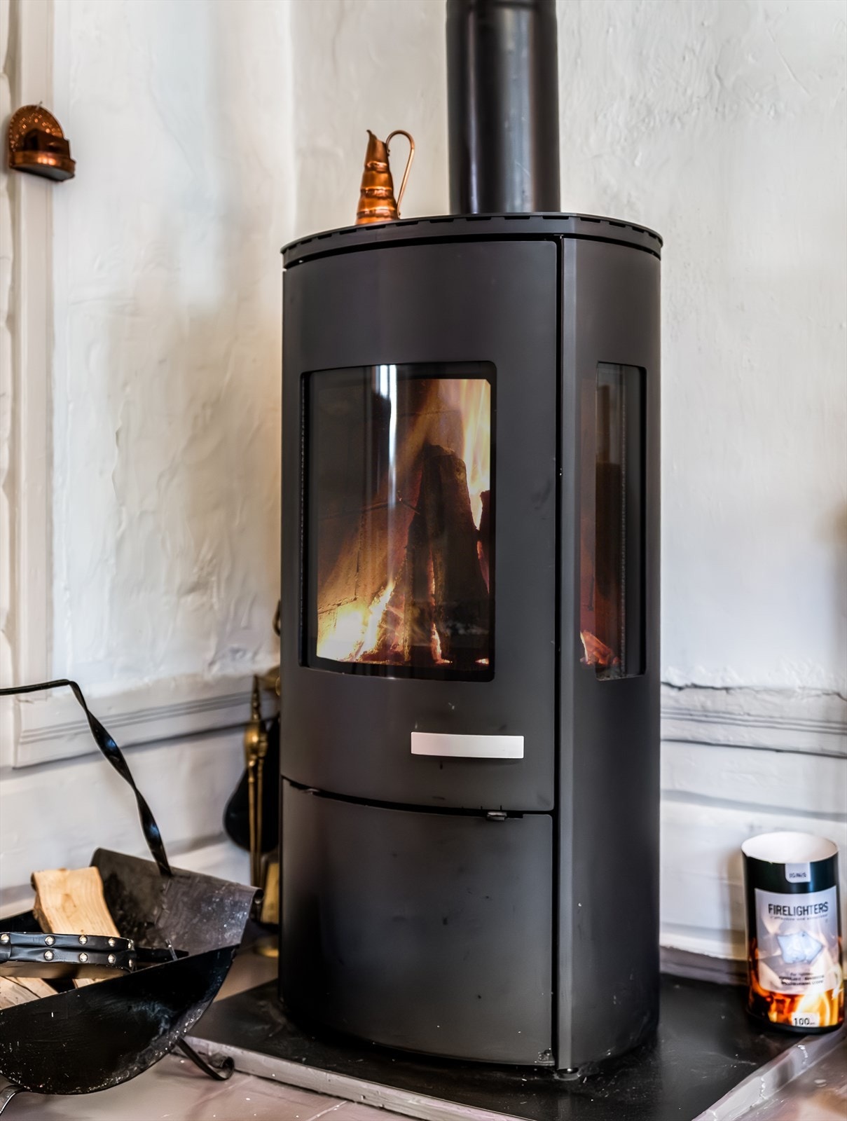 Moderne vedovn som gir en lun og koselig atmosfære til stua, perfekt for kalde vinterkvelder. Galleribilde