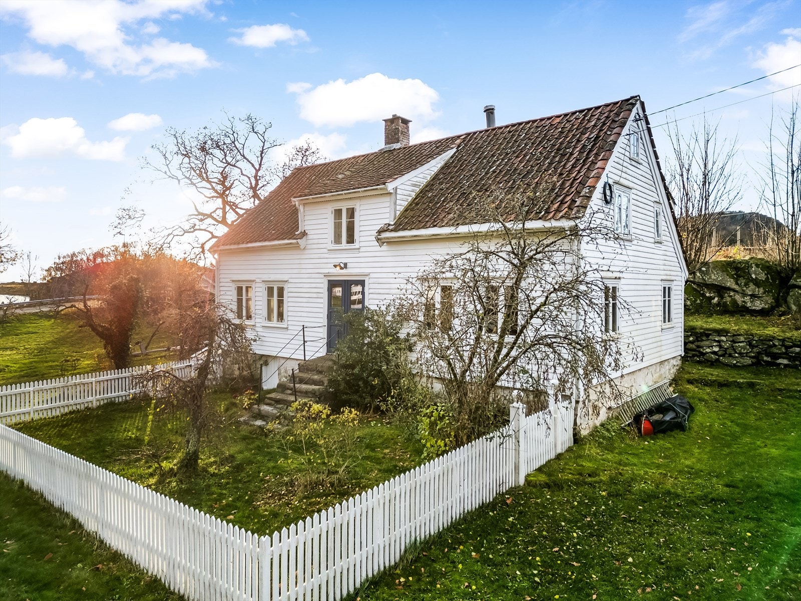 Fredelig hage innrammet av klassisk stakittgjerde - en perfekt kombinasjon av ro og sjarm. Galleribilde