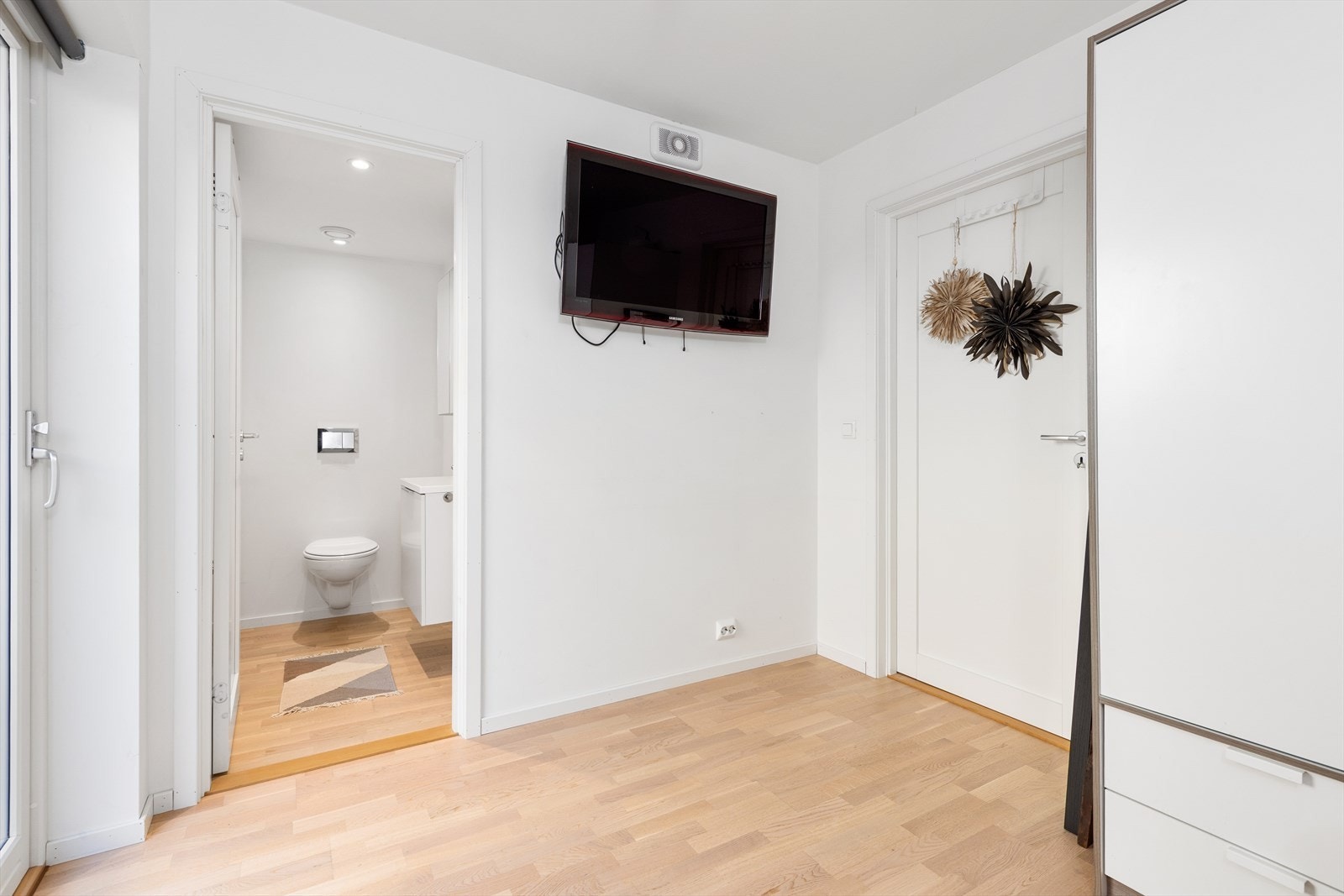 Soverom/tv-stue med videre utgang til terrasse på baksiden av boligen. Galleribilde