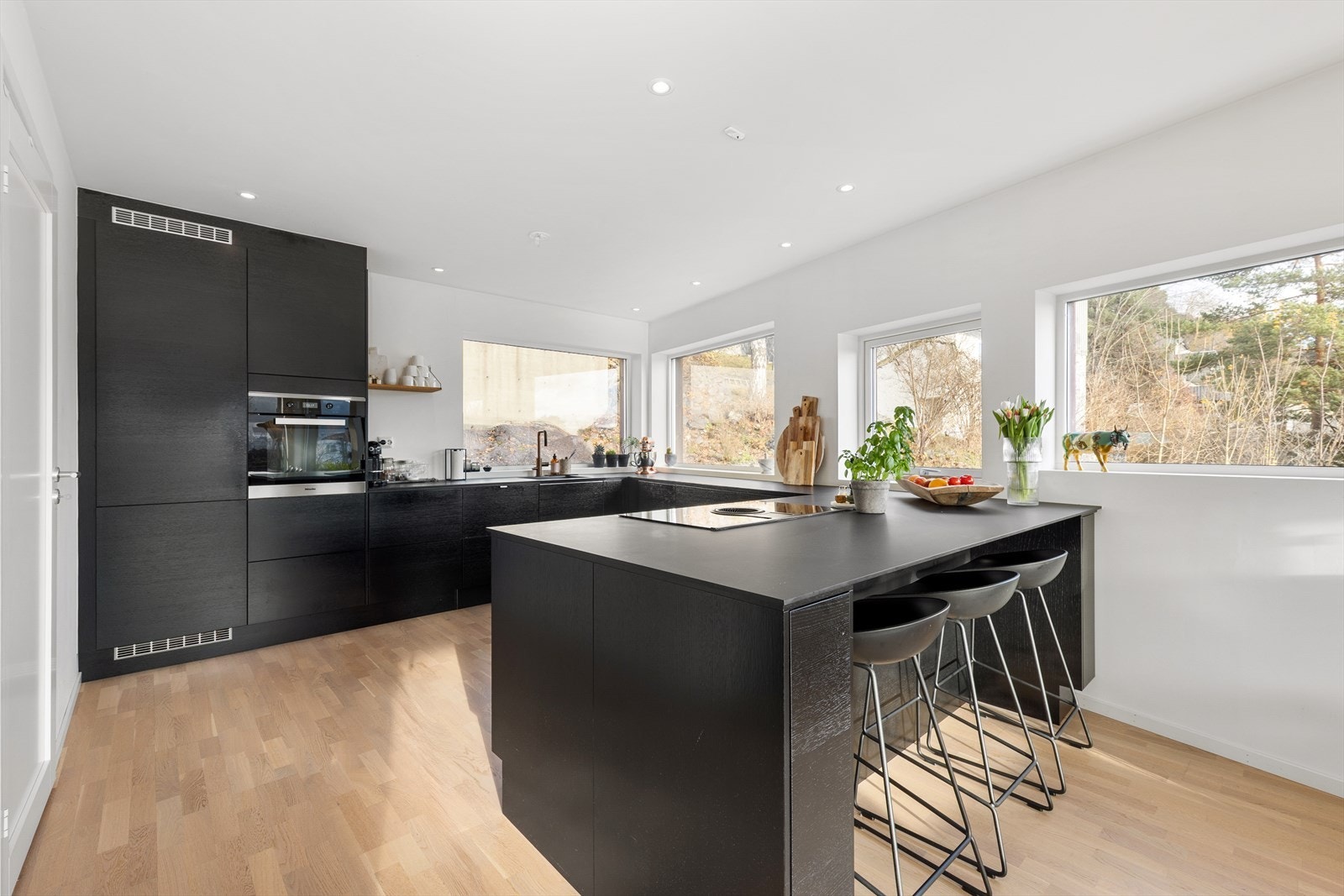 Stilren og moderne innredning med sorte slette fronter og benkeplate av typen laminat. Galleribilde