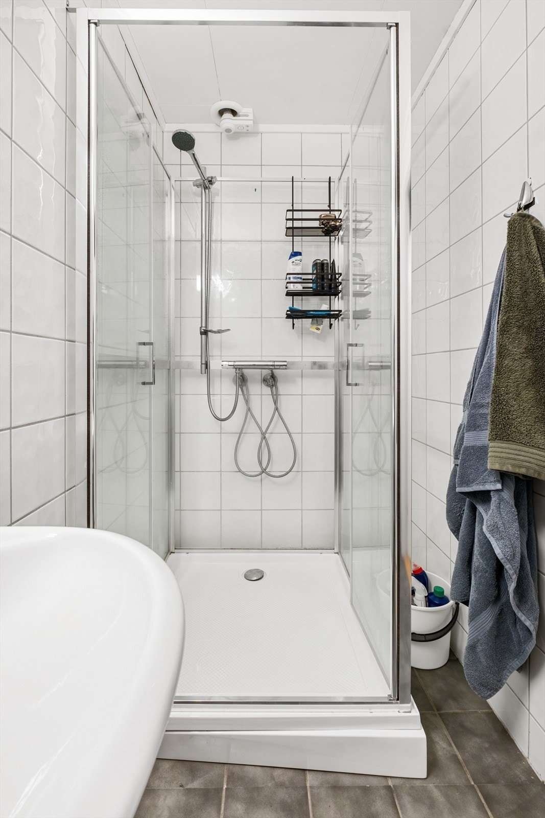 Rommet er innredet med dusjkabinett, frittstående toalett, vegghengt servant med speil og belysning Galleribilde