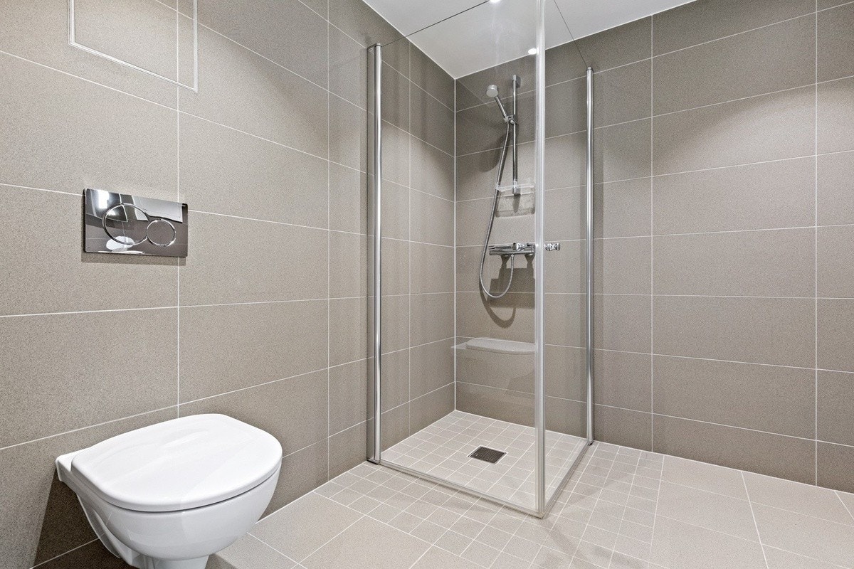 Flislagt bad med varmekabler og opplegg for vaskesøyle Galleribilde