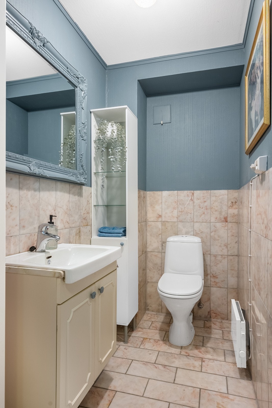 Begge toalettrom i hoveddel har fliser på gulv og delvis vegg. Toalettrom i 1. etasje er innredet med toalett og servantskap. Galleribilde