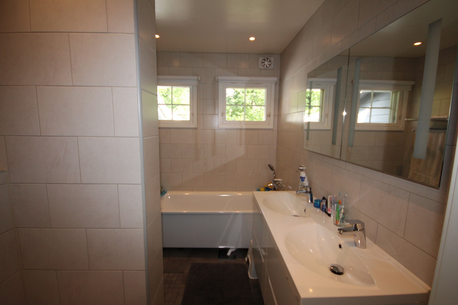 Lekkert flislagt bad med badekar og dusj Galleribilde