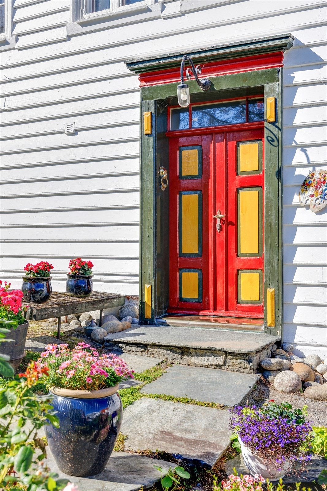 Fargerike inngangsdører gir en livlig kontrast til den hvite fasaden. Galleribilde