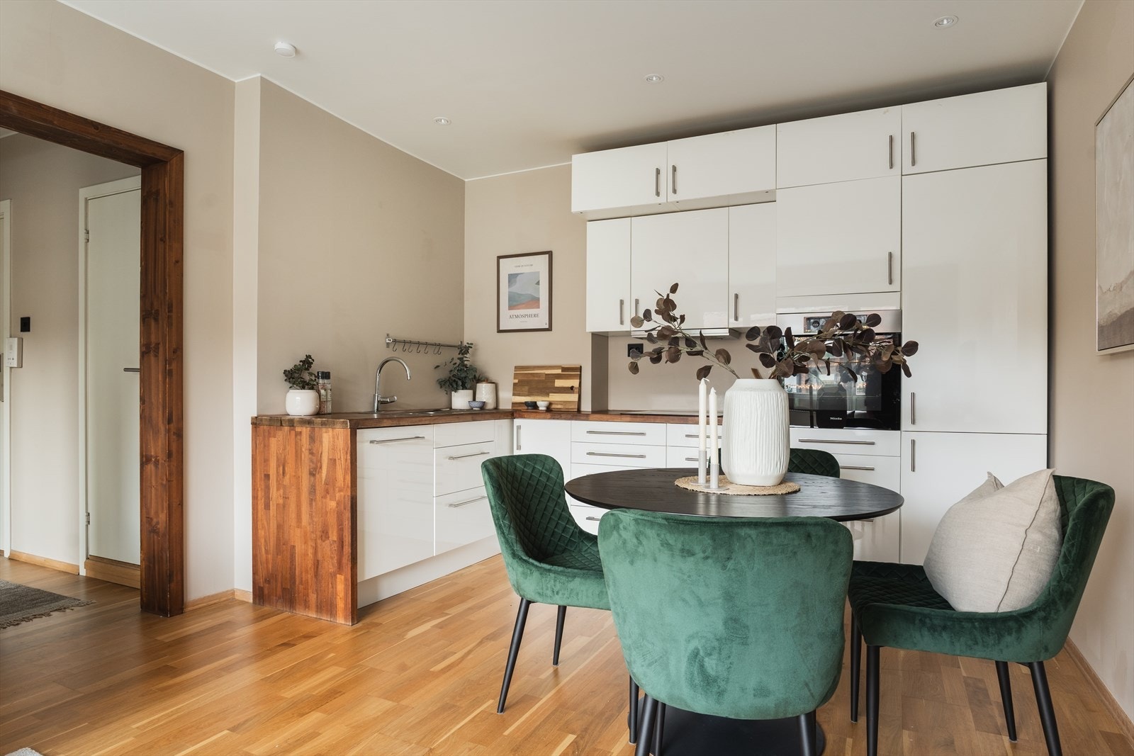 Lyst og innholdsrikt kjøkken utstyrt med integrert stekeovn, kjøleskap og oppvaskmaskin. Galleribilde