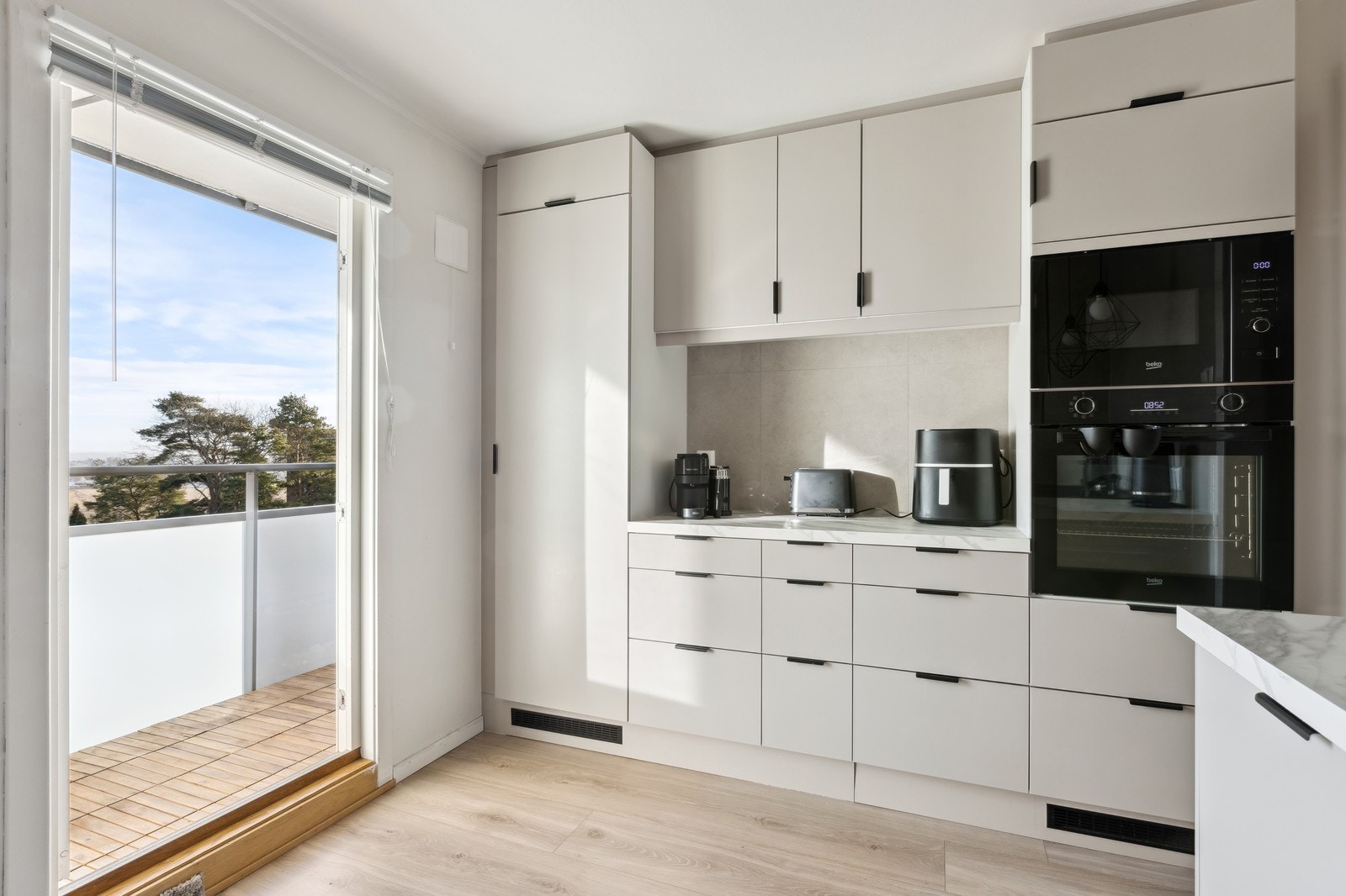 Kjøkkenet er lyst og innholdsrikt - utgang til balkong Galleribilde