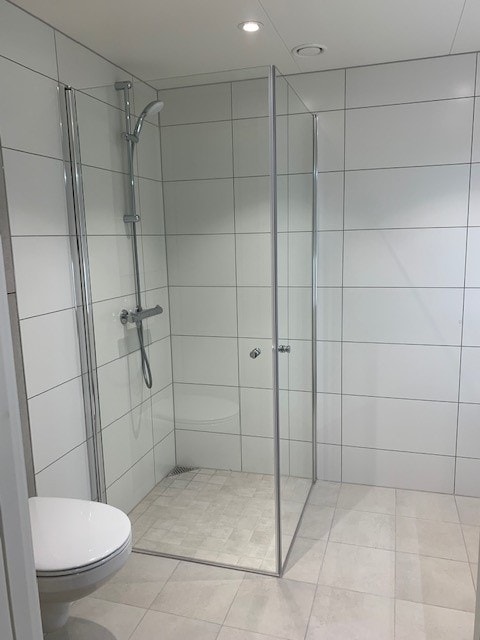 Bad med dusjhjørne, servant med underskap, vegghengt toalett. Opplegg for vaskemaskin. Galleribilde