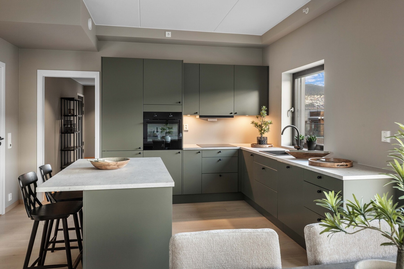 Alle hvitevarer er integrerte, og løsningen byr på godt med både arbeidsplass og oppbevaring. Galleribilde