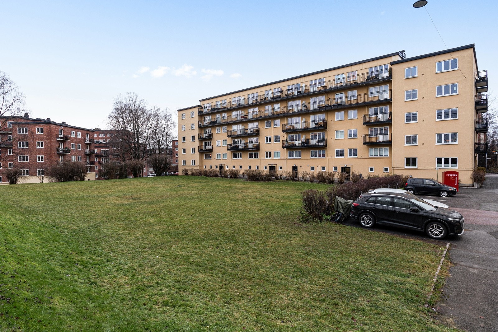 Utsikt mot en gresslagt gangvei med god avstand mellom bygningene. Den følelsen av rom og grøntområder er ganske sjelden i denne bydelen Galleribilde