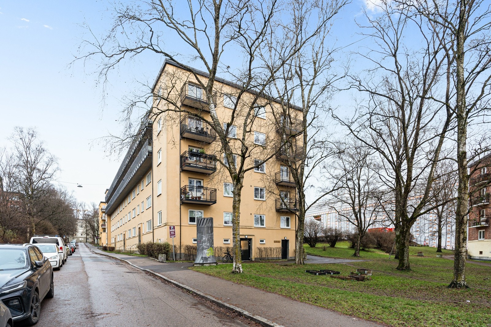 Fasade - Pent opprabeidet tomt med asfaltert adkomst, gangveier og biloppstillingsplasser. Gressplen med diverse busker og beplantinger. Galleribilde