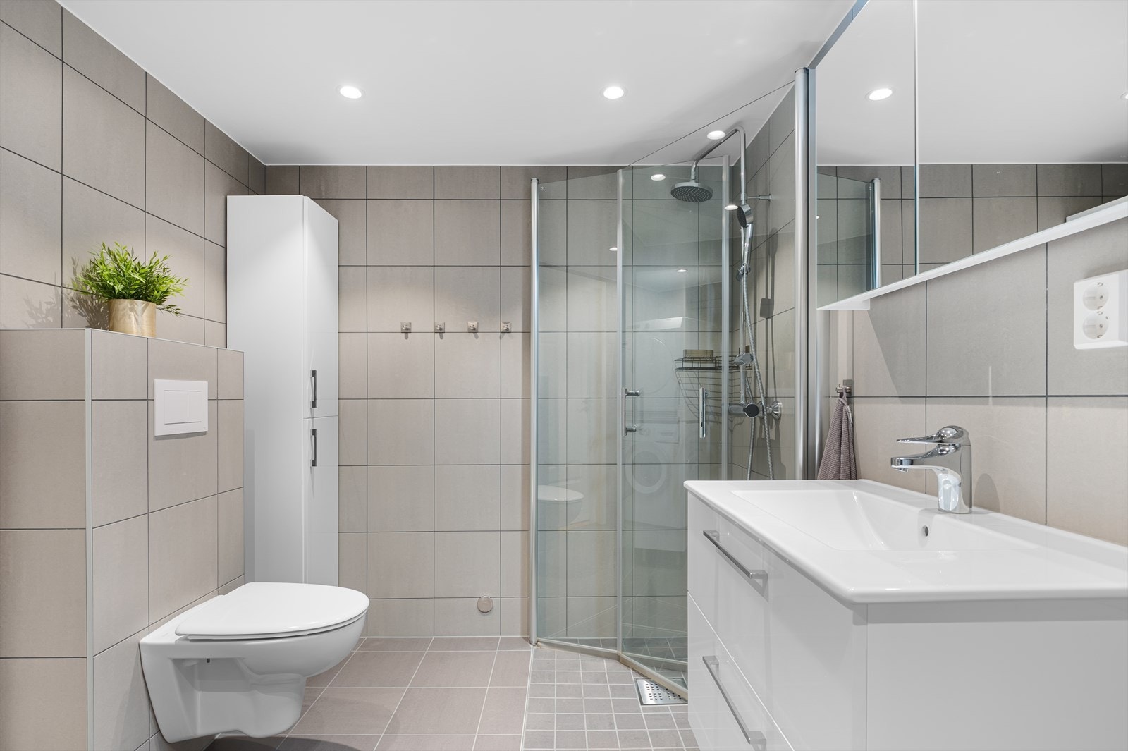 Badet som stod ferdig i 2023 har god størrelse og fremstår tidløst med flislagte overflater, gulvvarme, downlights og lys innredning. Galleribilde