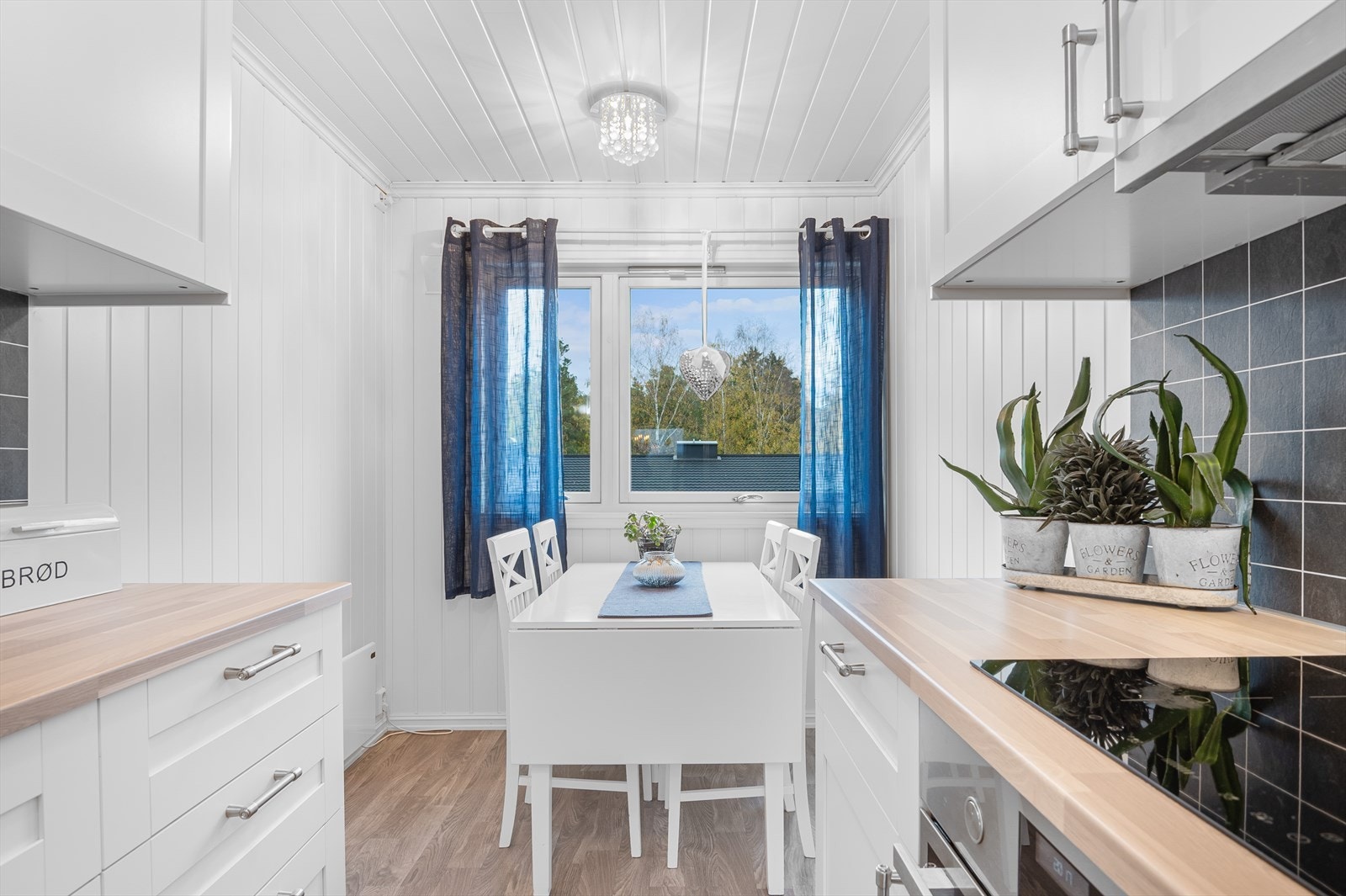 Det er plass til frokostbord ved vindu med hyggelig utsyn mot nabolaget. Galleribilde