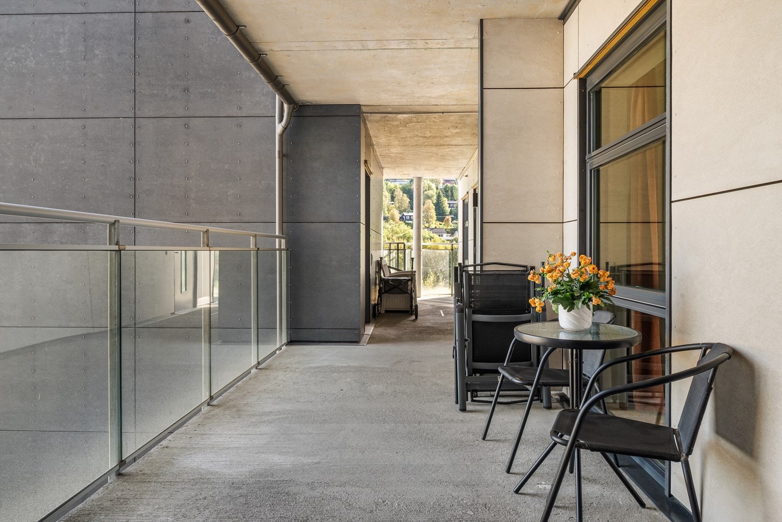 Skjermet inngangsparti med utemøbler. Her kan man sitte med kaffekoppen og slå av en prat med de andre hyggelige beboerne. Galleribilde