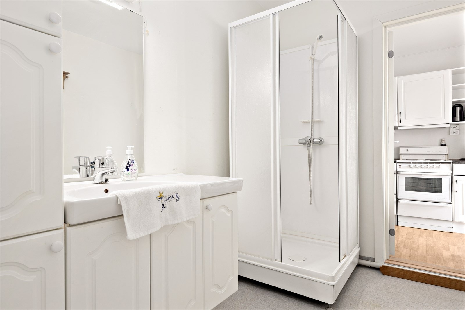 Badet har innredning med under- og høyskap med nedfelt servant. I rommet er det også tørkeskap, dusjkabinett og opplegg for vaskemaskin. Tak og vegg mot toalettrommet er nylig oppmalt. Galleribilde