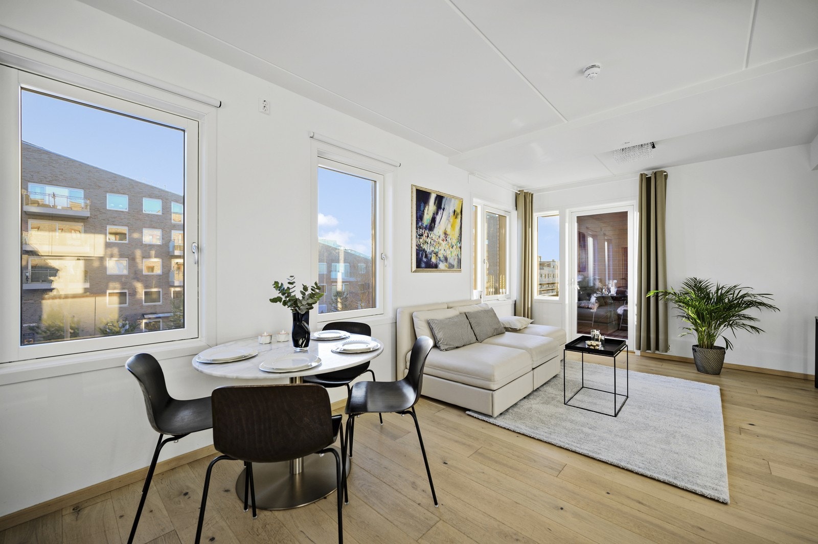 Åpen kjøkken/stue løsning med plass til spisebord og sittegruppe. Galleribilde